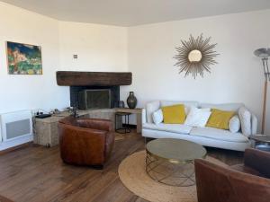 a living room with a couch and a fireplace at La Bretonne vue mer in Lanmodez