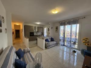 a living room with a couch and a kitchen at Fiore's house in Porto Santo Stefano