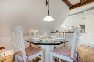 a kitchen with a dining room table with white cabinets at Sharky Bay in Keitum