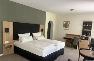 a bedroom with a bed and a desk and a table at Parkhotel Waldbreitbach in Waldbreitbach