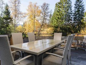 a table and chairs on a deck with trees at 2-Story Condo with Terrace in Åre