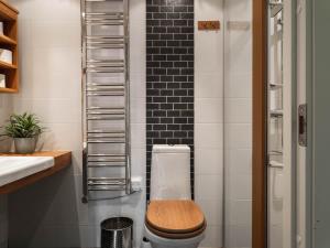 a bathroom with a toilet with a wooden toilet seat at 2-Story Condo with Terrace in Åre