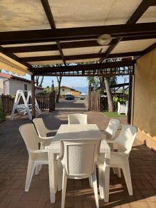 a white table and chairs under a pergola at Mespilia - Tra Mare e Città in Latina
