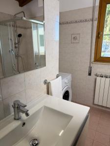 a bathroom with a sink and a washing machine at Mespilia - Tra Mare e Città in Latina +20 photos