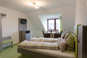a hotel room with two beds and a table at Gästehaus Ainser in Hagnau