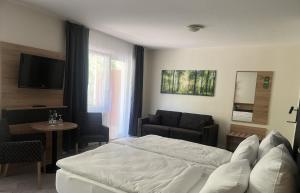 a bedroom with a bed and a chair and a table at Parkhotel Waldbreitbach in Waldbreitbach