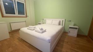 a bedroom with a white bed with towels on it at Oktheway Miño in Miño