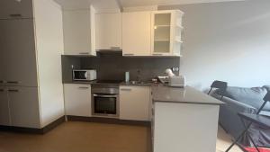 a kitchen with white cabinets and a counter top at Oktheway Miño in Miño