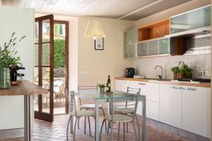 a kitchen with a glass table and chairs at Podere Sant'Alessandro in Rapolano Terme