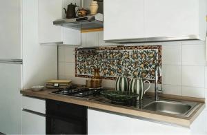 a kitchen with a sink and a stove top oven at Maison La Torretta in Vico Equense