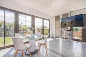 a dining room with a table and chairs and windows at Ferienhaus Sonnendeck in Ueckeritz