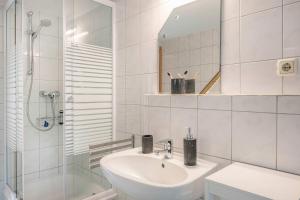 a white bathroom with a sink and a shower at Ferienhaus Sonnendeck in Ueckeritz +30 photos