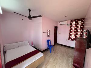 a bedroom with a bed and a blue chair at Hotel Bypass in Madurai