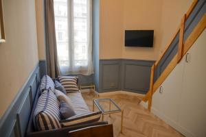 a living room with a couch and a tv at The Blue Cottage in Nice