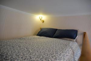 a bedroom with a bed and a light on the wall at The Blue Cottage in Nice