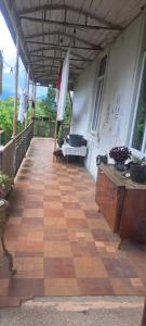 a patio with a table and a bench on a porch at Guramishvili 5 in Kobuleti
