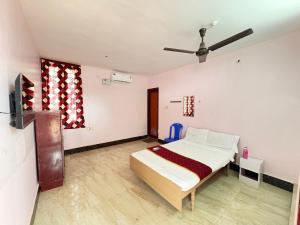 a bedroom with a bed and a ceiling fan at Hotel Bypass in Madurai