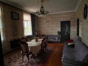 a living room with a table and a chandelier at Guramishvili 5 in Kobuleti