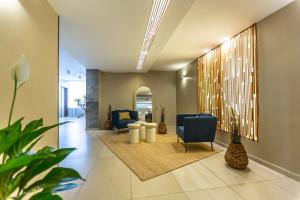 a hallway with a lobby with chairs and a table at Hotel Riviera in Mamaia +142 photos