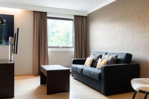 a living room with a couch and a window at Scandic Stavanger Park in Stavanger