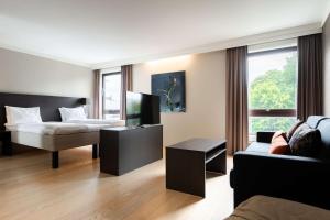 a living room with a bed and a couch at Scandic Stavanger Park in Stavanger