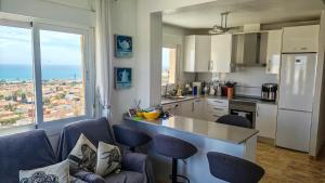 a kitchen with a large window and a kitchen with chairs at Casa Las Vistas in Bolnuevo
