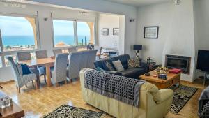 a living room with a couch and a table and chairs at Casa Las Vistas in Bolnuevo