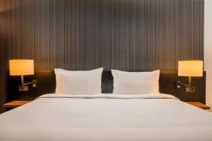 a bedroom with a large white bed with two lamps at Radisson Blu Hotel Amsterdam Airport, Schiphol in Schiphol +179 photos