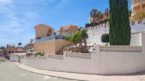 a house with a white fence and palm trees at Casa Las Vistas in Bolnuevo