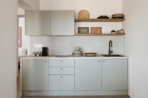 a kitchen with white cabinets and a sink at Halo Tinos - ARTEMIS in Tinos +19 photos