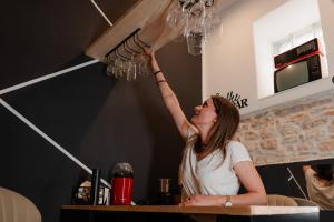 a woman standing in a kitchen with her hand in the air at Mariposa cinema in Grumo Appula
