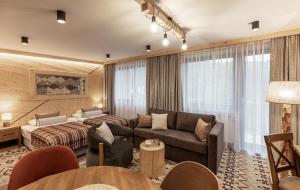 a hotel room with a couch and a bed at Apartamenty Solina 67 in Solina