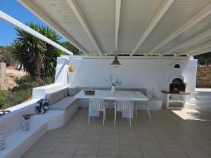 a white patio with a table and chairs on it at Minos Villa Antiparos in Antiparos