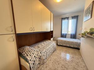 a small room with two beds and a cabinet at Fiore's house in Porto Santo Stefano