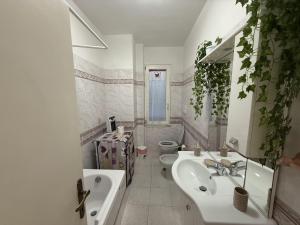 a white bathroom with a sink and a toilet at Fiore's house in Porto Santo Stefano +5 photos