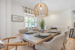 a dining room table with chairs and a chandelier at Düne in Keitum