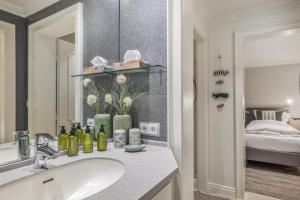 a bathroom with a sink and a mirror and a bed at Düne in Keitum +23 photos