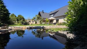a house with a pond in front of a house at Haus Kirijan in Garbsen