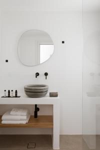 a white bathroom with a sink and a mirror at Halo Tinos - ARTEMIS in Tinos