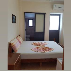 a bedroom with a bed with a shell on it at Onde Rooms in Vlorë