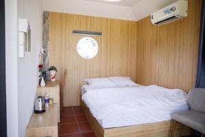a bedroom with a bed and a clock on the wall at LUA Farmstay in Bà Rịa
