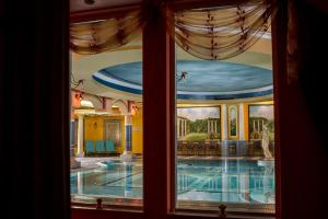 a view of a swimming pool through a window at Papuga Park Hotel Wellness Marrakesz & SPA in Bielsko-Biała