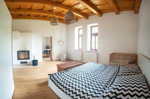 a bedroom with a large bed and a living room at Pod Skalou in Temeš