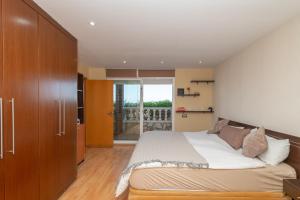 a bedroom with a large bed and wooden cabinets at House close to the beach! Pool, ocean view! in Santa Susanna +50 photos
