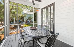 a patio with a table and chairs on a porch at Southern Living Cottage in Santa Rosa Beach