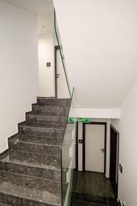 a staircase in a building with a green sign on it at ADORA's VIEW HOTEL in Sarandë