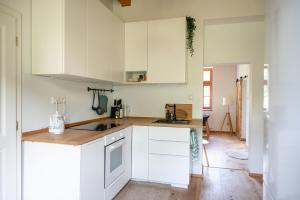 a kitchen with white cabinets and a wooden counter top at Pod Skalou in Temeš