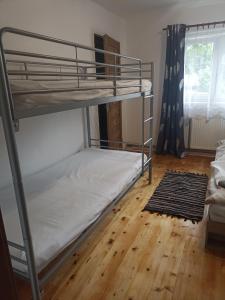 a bedroom with two bunk beds and a wooden floor at Apartmán Slepička in Weissbach
