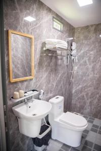 a bathroom with a sink and a toilet and a mirror at LUA Farmstay in Bà Rịa