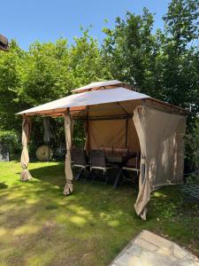 a gazebo with a table and chairs in a yard at Les Crins Du Bonheur Chambre et Table Hôtes Belle Vue in Fraisse